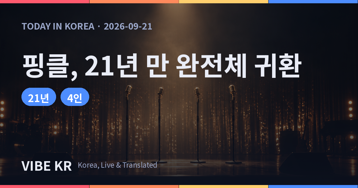 따뜻한 조명이 비추는 빈 공연 무대에 마이크 스탠드 네 개가 놓여 있는 모습.